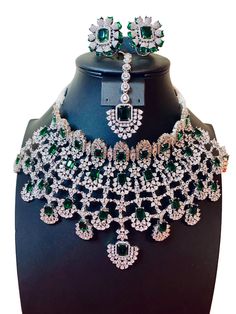 This stunning necklace set is inspired by actress Kiara Advani's wedding look. Made with high-quality CZ American diamonds , it features vibrant green stones for a touch of color and elegance. Perfect for parties or special occasions, this set is a must-have for any jewelry collection. Bring the glamour of Bollywood to your wardrobe with this Kiara Advani inspired necklace set. Rhodium Finish Jewellery Care- Keep the jewellery dry, avoid contact with perfumes and water. Hand Set Emerald Jewelry Sets For Wedding, Hand Set Emerald Necklace For Wedding, Hand-set Emerald Necklace For Weddings, Wedding Emerald Necklace Hand Set, Party Crystal Emerald Necklace Hand Set, Elegant Green Lehenga With Stone Work, Bollywood Bridal Necklace With 17 Green Jewels, Hand Set Emerald Necklace For Reception, Green Emerald Necklace With Stone Work For Wedding