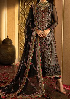 Introducing our Winter collection 'VELVET FESTIVE' by Asim Jofa designed to make you look and feel your best these pieces will add a touch of class and elegance to your wardrobe. In a captivating dance of colors and motifs, this onyx elite ensemble unfolds like a love story waiting to be told. It's a masterpiece embroidered with intricate motifs, where threads of gold are echoing the ancient art of Meenakari. These motifs breathe life into the attire, a tribute to the rich flora and fauna of South Asia, painting a vivid picture of nature's abundance. The shirt and dupatta, born of the same fabric, share a secret world adorned with delicate cupped sequins, zari, and threads in the hues of magenta and green. The borders of the hem, sleeves, and shirt, cloaked in sumptuous velvet, bring an el Festival Georgette Salwar Kameez With Resham Embroidery, Semi-stitched Long Georgette Churidar, Bollywood Georgette Unstitched Suit For Festivals, Long Georgette Dupatta, Long Georgette Sharara With Dupatta, Traditional Georgette Wear With Sheer Dupatta, Semi-stitched Georgette Churidar For Festivals, Bollywood Style Georgette Unstitched Suit For Navratri, Unstitched Georgette Churidar For Festivals