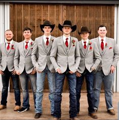 a group of men in suits and ties standing next to each other with hats on