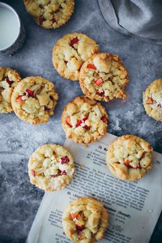 several cookies with cranberries and white chocolate are on top of an old book