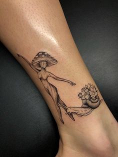 a woman's leg with a tattoo on it and a flower in the vase