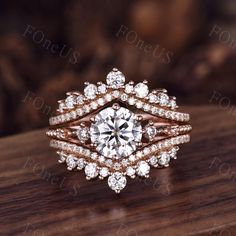 a diamond ring with two rows of diamonds on top of it, sitting on a wooden surface