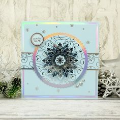 a close up of a greeting card with snowflakes and pine cones on it