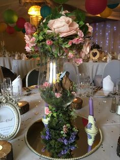 a vase filled with flowers sitting on top of a table next to plates and glasses