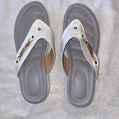 White Wedge Sandals With Gold Accents Never Worn White Toe Post Comfortable Sandals, White Wedge Heel Flip Flops For Beach, White Toe Post Wedge Sandals For Beach, Casual White Wedge Sandals For Beach, White Wedge Heel Flip Flops For Spring, Comfortable White Open Toe Wedge Sandals, White Wedge Heel Flip Flops, White Wedge Heel Casual Flip Flops, White Flat Wedge Sandals Casual