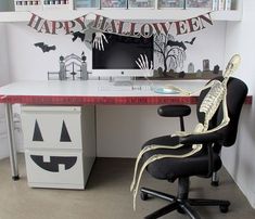 an office desk decorated for halloween with skeleton decorations on the wall and black chair in front