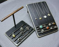 an assortment of jewelry is displayed on a table with a pen and pencil in it