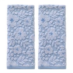 two blue towels with flowers on them are next to each other in front of a white background