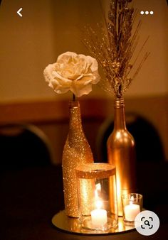 two vases with flowers and candles on a table