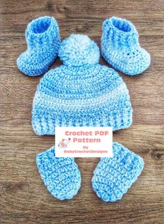 a crocheted hat, booties and mittens on a wooden surface