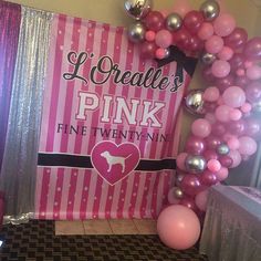 there is a pink and silver balloon arch in front of the table with balloons on it