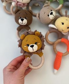 crocheted animal rings are being held by someone's hand with scissors in front of them