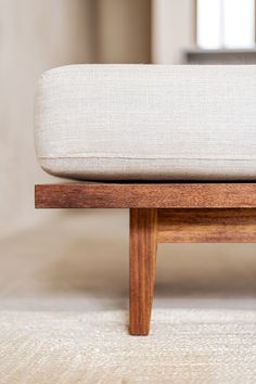 a close up of a wooden bench with a white cushion on it's back