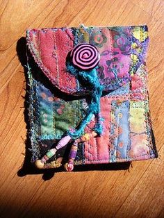 a small patchwork wallet with a candy lollipop in the middle on a wooden table