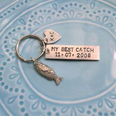 a metal keychain with a fish on it that says, my best catch 11 01 08