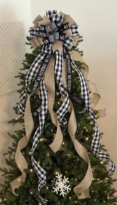 a christmas tree decorated with ribbon and snowflakes