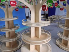 several wooden shelves with apples on them in a room filled with tables and chairs, all made out of plywood