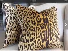 two leopard print pillows sitting on top of a couch