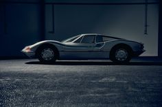 a silver sports car parked in an empty parking lot with no one around it at night