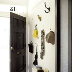 there is a black door and some hats on the wall