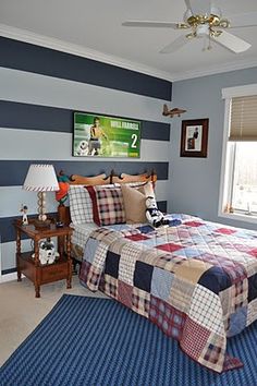 a bed room with a neatly made bed next to a window and a ceiling fan