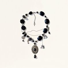 Elevate your Halloween style with this upcycled black gothic necklace adorned with spooky spiders and fascinating pendants. Handcrafted using a mix of plastic and glass beads, this unisex accessory is perfect for adding a touch of mystery to your ensemble. The stainless steel fittings ensure durability while maintaining a modern edge. Stand out this Halloween season with this unique and versatile necklace that exudes a hauntingly chic vibe. ✤length : 14 inch + 1 extender chain (you can add or reduce the length, write to me about it) I am not responsible for any damage or injuries done from wearing this item after shipping, along with any stones coming loose or breakage. ✤ It is a Vintage item and there is some wear and tear on it, but that is why it is an assemblage and it adds charm and c Spooky Necklace, Black Halloween Necklace With Lobster Clasp, Halloween Black Metal Necklace, Witchy Black Halloween Jewelry, Black Witchy Jewelry For Halloween, Black Punk Pendant Necklace, Witchy Black Jewelry For Halloween, Gothic Black Necklace With Lobster Clasp, Black Gothic Necklace With Lobster Clasp