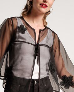 Indulge in the ethereal and dreamy organza Parker Swing Jacket. The weightless top boasts a delicate sheer construction and scattered floral appliques that will add grace to any look. Lightweight sheer mesh women's swing jacket Featuring scattered floral appliques Full-length sleeves with one front tie Material: 100% Polyester Made in India Black Jacket Outfit, Simple Long Dress, Organza Jacket, Sheer Jacket, Organza Top, Mesh Jacket, Essential Dress, Short Jumpsuit, Sweater Coats