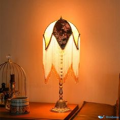 a lamp that is sitting on top of a table next to a birdcage