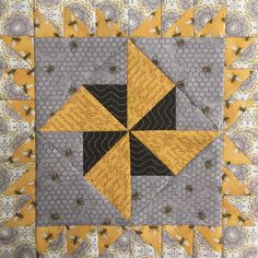 a yellow and gray quilt with some black and white designs