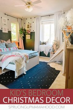 a kid's bedroom decorated for christmas with blue and white bedding, stars on the ceiling