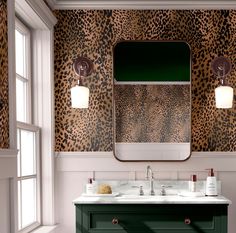 a bathroom with leopard print on the wall and green cabinetry, along with two sinks