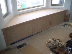 a window seat in the corner of a room with construction materials on the floor next to it