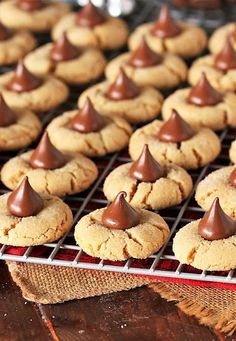 some cookies with chocolate on top are cooling on a rack in front of other cookies