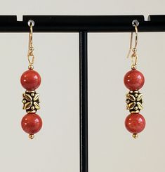 Stunning Red Coral Bamboo Coral Drop Earrings in 6mm Round Beads. Center Antique 14K Gold Plated Floral Bead and 14K Gold Filled Round Beads for accent. 14K Gold Filled Bali Hook Ear Wires with Ball Ends. Other Wires/Studs/Lever Backs upon request. Drop Length 1 1/2". See Matching Beaded Necklace and Jewelry Set on our Jewelry Boards. Awesome Red with a hint or Orange. Nice way to show your class with real Beads from Nature! Gold Earrings With Gemstone Beads, Gold Earrings With Polished Beads For Gift, Gold Spiritual Earrings With Gemstone Beads, Coral Drop Earrings, Red Bamboo, Red Coral Earrings, Bamboo Coral, Coral Earrings, Jewelry Boards