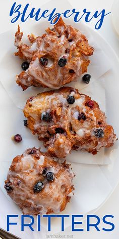 three blueberry muffins on a white plate with silverware next to it