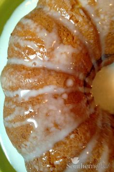 a glazed donut sitting on top of a green and white plate covered in icing