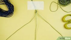 several different types of cords and scissors on a yellow surface with white paper attached to them