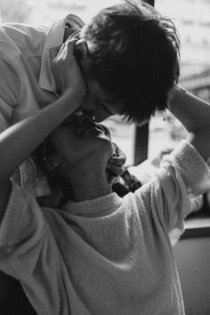 a man and woman kissing each other in black and white