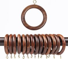 a close up of a wooden curtain rod with rings and chains hanging from it's end