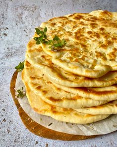 a stack of flat bread on top of a cutting board