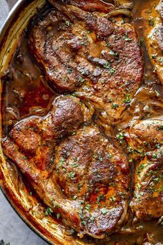 steaks with sauce and herbs in a skillet