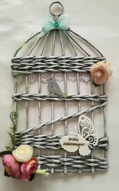 a bird in a cage with flowers on the side