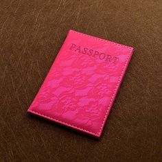 a pink passport case sitting on top of a brown table