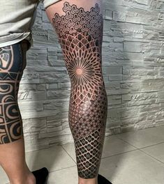 a man's leg with an intricate tattoo on it