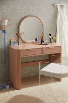 a dressing table with a mirror, stool and other items on the floor next to it