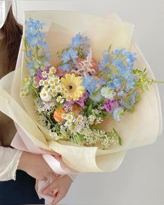 a woman holding a bouquet of flowers in her hands