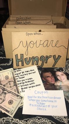 an open box with some money and other items inside it on a bed sheet that says, you are hungry