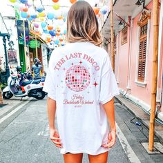 a woman is walking down the street in shorts and a t - shirt that says the last disco