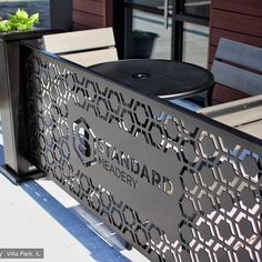 an outdoor table with chairs and a planter on it