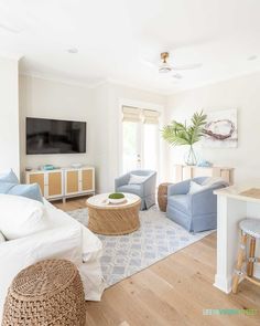 a living room filled with furniture and a flat screen tv mounted to the side of a wall